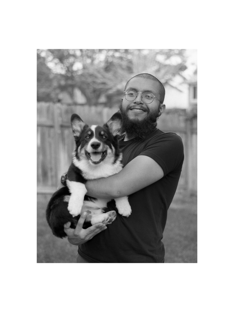 A man with a beard smiling while holding a dog