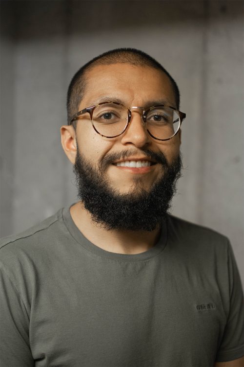 Headshot photo of a man with a beard and glasses