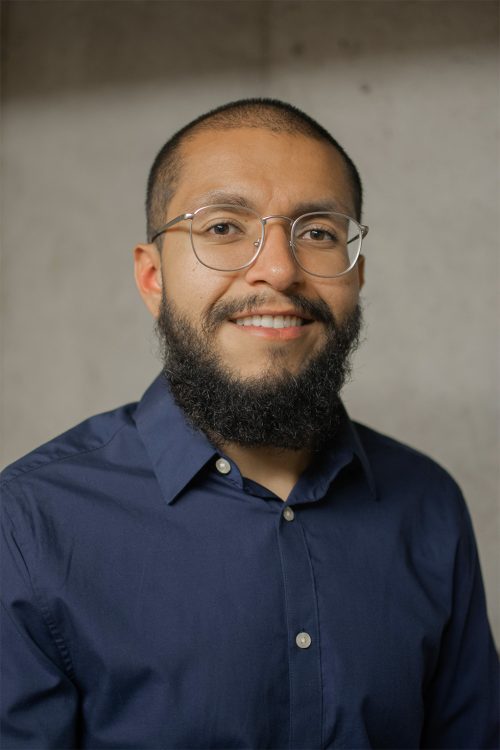 Headshot photo of a man with a beard and glasses