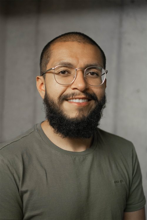 Headshot photo of a man with a beard and glasses