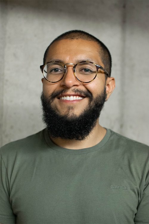 Headshot photo of a man with a beard and glasses